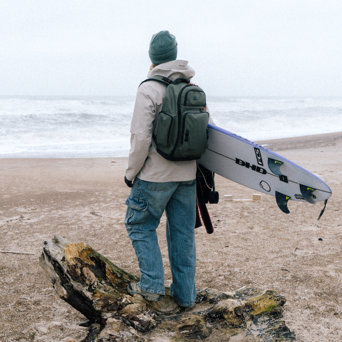 FCS Day-X Pack 24L at the beach with a surfboard